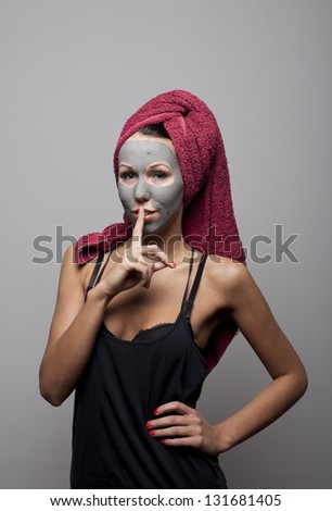 Clay facial mask. The portrait of young woman. Silence please!