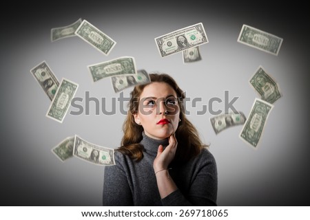 Girl in grey and falling dollar banknotes. Currency and lottery concept.