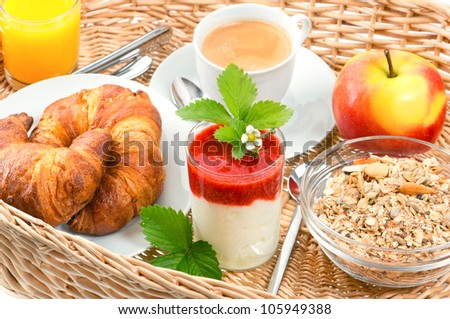 breakfast with coffee, croissants, orange juice and fresh strawberry yogurt