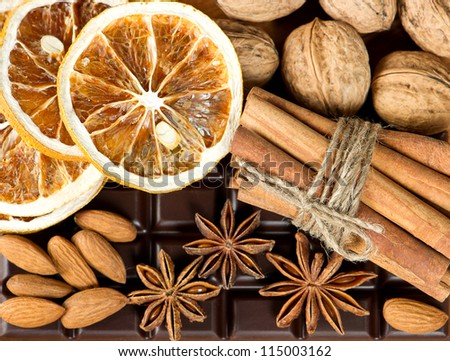 chocolate with cinnamon sticks, anise stars, nuts and sliced of dried orange. food background