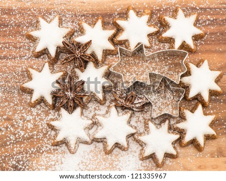 cinnamon stars and star anise on wooden background with sugar powder. christmas bakery. top view
