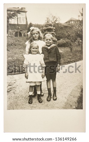 BERLIN, GERMANY - CIRCA 1916: group of children wearing vintage clothing with a old house on background, circa 1916 in Berlin, Germany