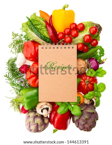 recipe book with fresh organic vegetables and herbs isolated on white background. raw food. healthy nutrition ingredients