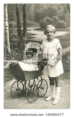 BERLIN, GERMANY - CIRCA 1930: old photo of little girl with doll toy. nostalgic vintage picture from ca. 1930, in Berlin, Germany