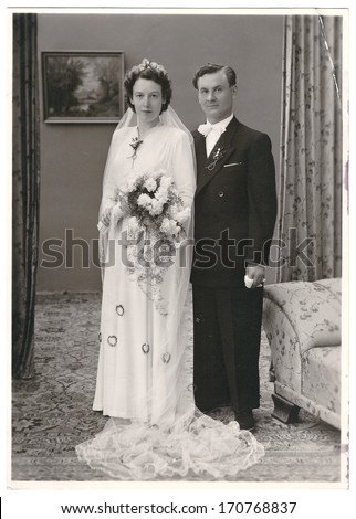 MUNICH, GERMANY - CIRCA 1950: vintage wedding photo. portrait of just married couple. bride and groom wearing vintage clothing. Illustrative Image, subject of human interest. original film grain