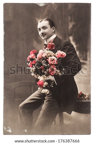 FRANCE, PARIS - CIRCA 1917: portrait of young man with rose flowers. Typical for this period mans look. Illustrative Image, subject of human interest