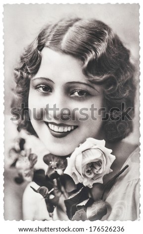 FRANCE, PARIS - CIRCA 1920: portrait of young woman with rose flowers. Typical for this period womans look
