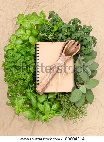 recipe book with variety fresh herbs and decoration. cooking background