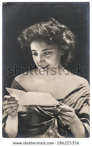 FRANCE, PARIS - CIRCA 1904: original antique portrait of young woman reading love letter. Typical for this period womans look