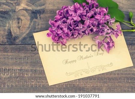 lilac flowers on wooden background. greeting card with sample text Happy Mother\'s Day! retro style toned picture