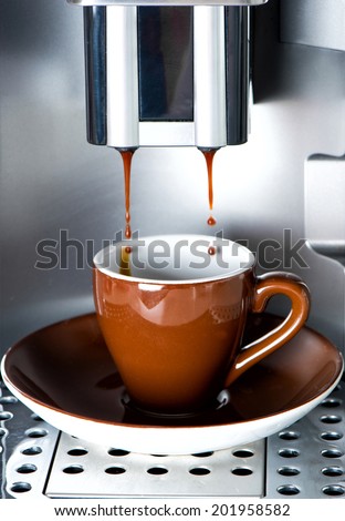 Coffee maker pouring fresh espresso coffee in a cup. Food and beverage