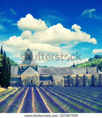 Senanque abbey with lavender field, landmark of Provence, Vaucluse, France. Beautiful landscape with medieval castle and cloudy blue sky. Retro style toned picture
