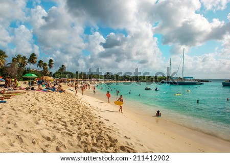 ST. MAARTEN, NETHERLANDS ANTILLES - JANUARY 1, 2014: People relaxing anf have fun on Sunset Beach of Sint Maarten, Caribbean island of the Kingdom of the Netherlands, Netherlands Antilles