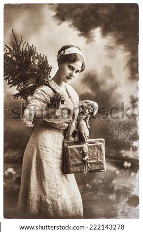 young woman with christmas tree and gifts, antique picture with original scratches and film grain
