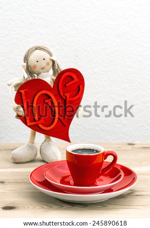 Cup of Coffee and red Valentines Day decoration. Doll girl with LOVE