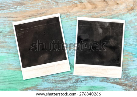 Vintage style polaroid photo frames on rustic wooden background. Scratched texture