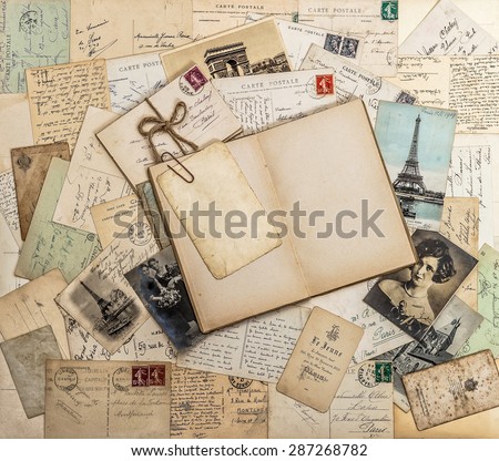 Open book, old letters and postcards. Used paper background. Travel memories scrapbook for France and Paris
