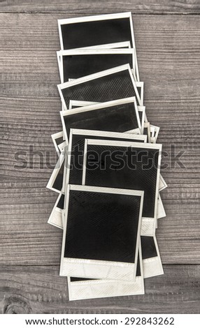 Retro style instant photo frames on rustic wooden background