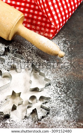 Flour, rolling pin and cookie cutters. Christmas baking. Festive food. Vintage style toned picture