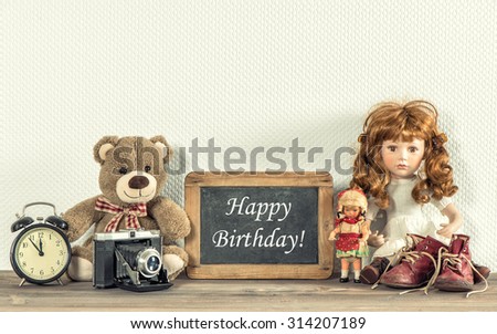 Doll, Teddy Bear, vintage toys and chalkboard with sample text Happy Birthday! Retro style toned. No name toys