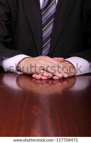 man with hands on desk is ready to listen to somebody