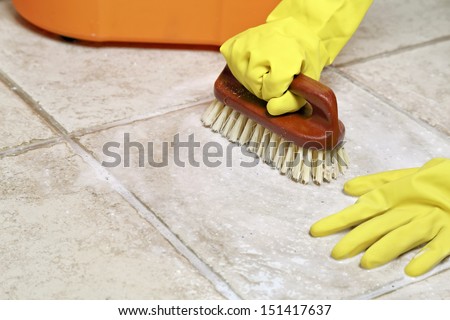 hands in rubber gloves scrubbing the floor