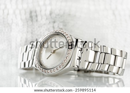 closeup of luxurious chrome watch against blurry background