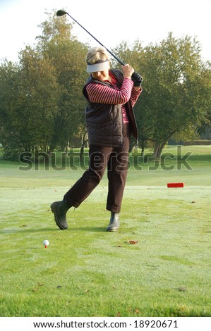 Female golfer teeing off