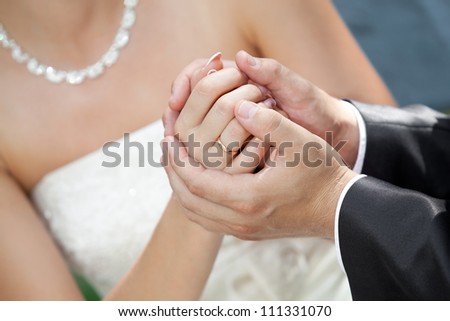 The groom holds the bride\'s hand.
