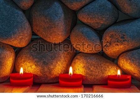 Candles are lit on the background of the sauna stones. Preparing for the ceremony bathhouse