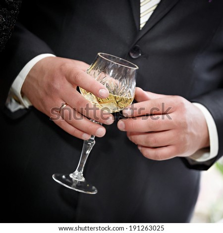 Wedding wine glass in hand of the groom.