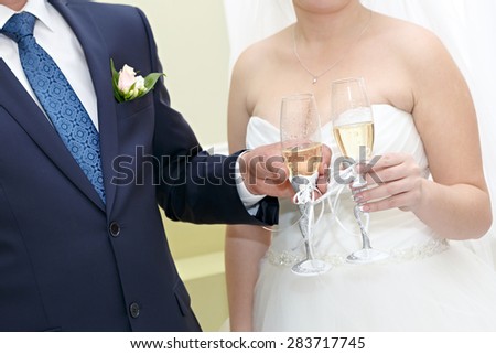 Glasses of wine in the hands of the bride and groom at a wedding party.