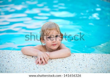 Portrait of funny little girl in swimming pool having fun