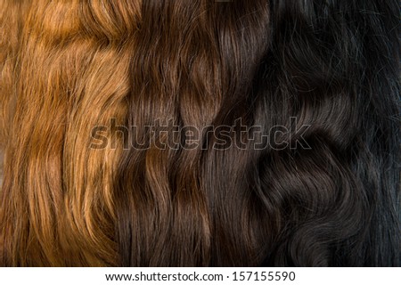 Locks of faux hair for beauty saloon different colors and structure. Blond, red and brunette on gray background