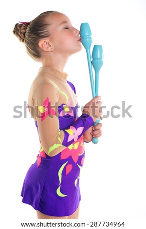 Beautiful toddler sport girl with purple rhythmic gymnastic suit kissing her lucky blue clubs