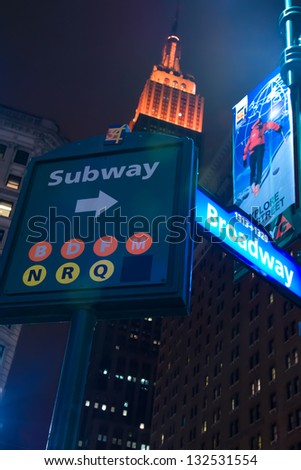 NEW YORK - JAN. 15: The Empire State Building, behind a NYC subway sign, is lit orange on the January 15, 2013. The Empire State Building is 1,250 feet (381 meters), with its antenna spire included.