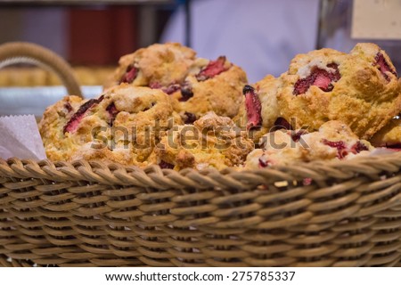 Lined straw basket of filled with delicious strawberry scones dusted with sugar crystals, and bread