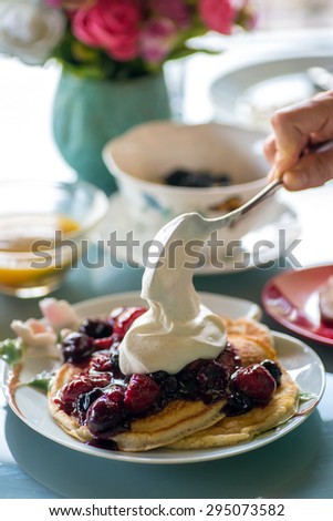 Gourmet breakfast and brunch setting with savory waffles and pancakes topped with fresh fruit puree reduction on fancy plates