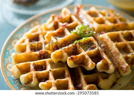 Gourmet breakfast and brunch setting with savory waffles and pancakes topped with fresh fruit puree reduction on fancy plates