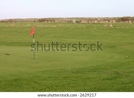 A golf ball on the fringe of a green.