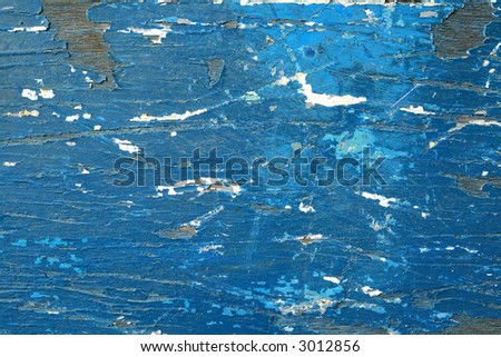 Flaky blue paint on a boat hull.