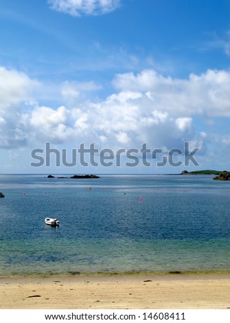 White clouds and blue sky over a calm sea, Porthcressa St. Mary\'s Isles of Scilly.
