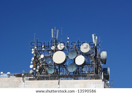 A cluster of antennas on top of a telecommunication-agency building