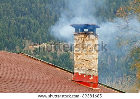Smoke coming out of a chimney of a mountain house