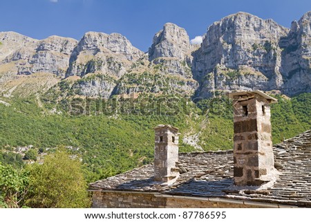 The high cliffs of Papigo (called towers) behind the typical stone house of Zagori area, Greece