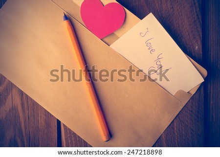 Symbolic heart of cardboard inserted into the envelope. Valentine\'s Day.  Retouching in retro style
