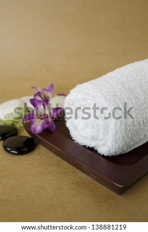 white spa towel roll on wooden tray with orchid
