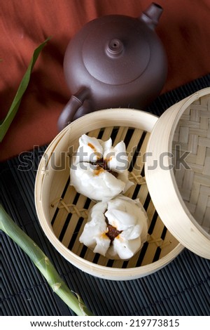 salapao in bamboo tray with tea pot on background