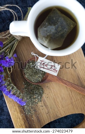 hot tea cup with tea bag on wooden board with tea time tag