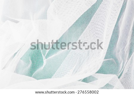 white mesh fabric on green background
